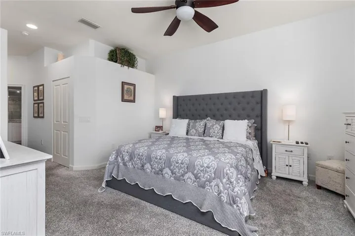 Carpeted bedroom with ceiling fan and baseboards