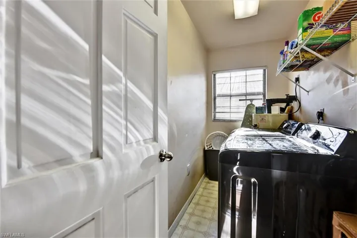 Laundry area with light floors, separate washer and dryer, laundry area, and baseboards