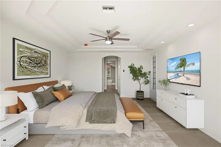 Bedroom featuring visible vents, ceiling fan, recessed lighting, a raised ceiling, and arched walkways