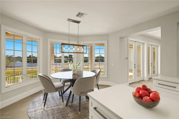Dining space featuring an inviting chandelier, french doors, baseboards, a water view, and visible vents