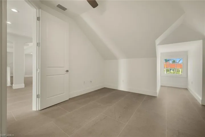 Bonus room with lofted ceiling and ceiling fan