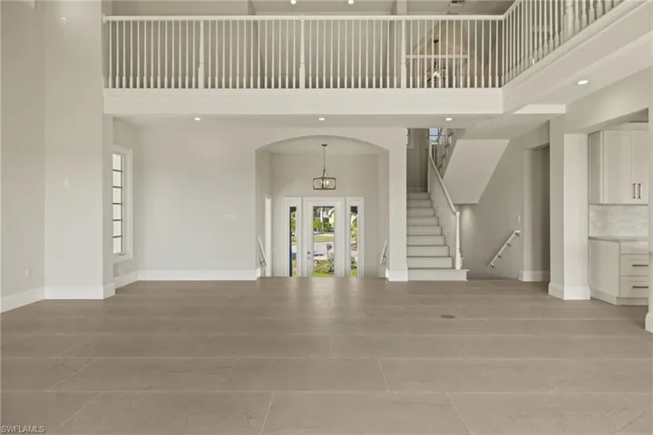 Tiled entrance foyer featuring a towering ceiling