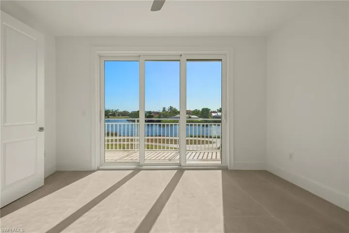 Empty room with light tile patterned floors and a water view