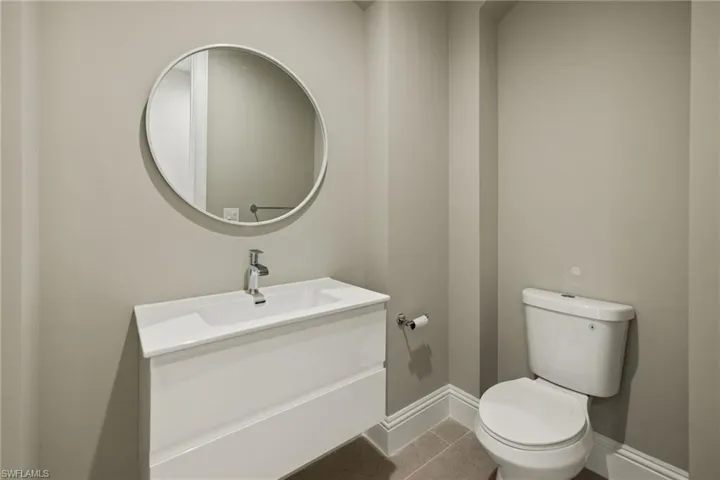 Bathroom featuring toilet, vanity, and tile patterned floors