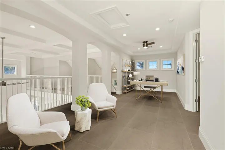 Sitting room with a raised ceiling, attic access, recessed lighting, baseboards, and beamed ceiling
