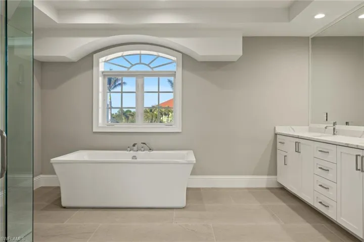 Bathroom featuring tile patterned flooring, a bathtub, and vanity