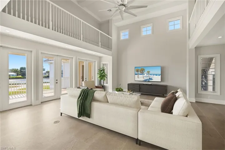 Living area featuring french doors, recessed lighting, a towering ceiling, and ceiling fan