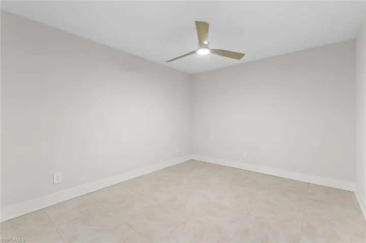 Unfurnished room featuring light tile patterned flooring and ceiling fan