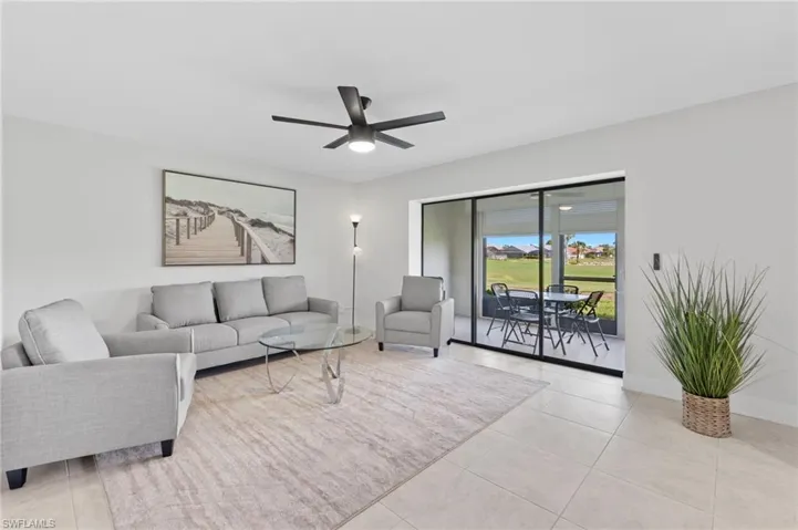 Living room featuring light tile patterned floors and ceiling fan