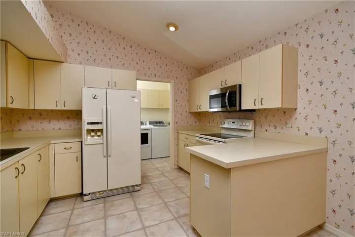 Laundry room  located at the end of the kitchen that then leads out into the garage