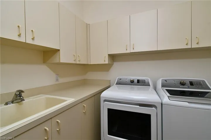 Laundry with washer and dryer and utility tub along with many cabinets