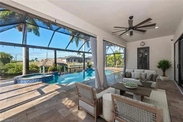 View of swimming pool with a patio area, a sunroom, a pool with connected hot tub, an outdoor hangout area, and a lanai