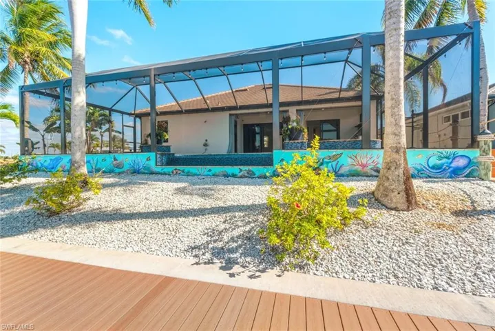 Back of property with a lanai, a sunroom, and stucco siding