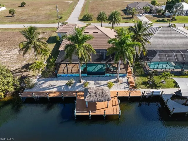 Aerial view of property and surrounding area with a pool and a large body of water