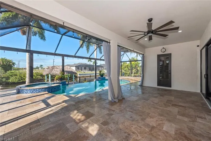 View of swimming pool featuring a sunroom, a patio area, a pool with connected hot tub, and a lanai