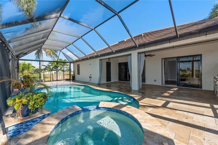 View of swimming pool with a sunroom, a pool with connected hot tub, a patio, and a lanai