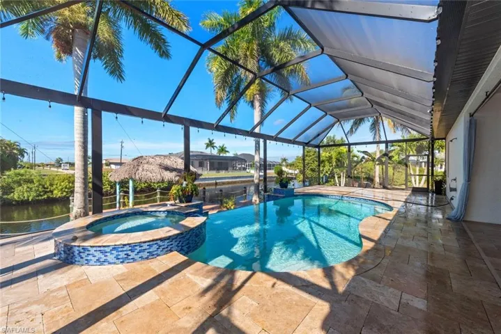View of pool with a sunroom, a patio area, a pool with connected hot tub, and a lanai