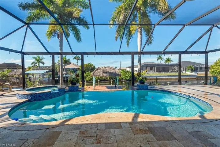 View of pool featuring a sunroom, a pool with connected hot tub, a lanai, and a patio