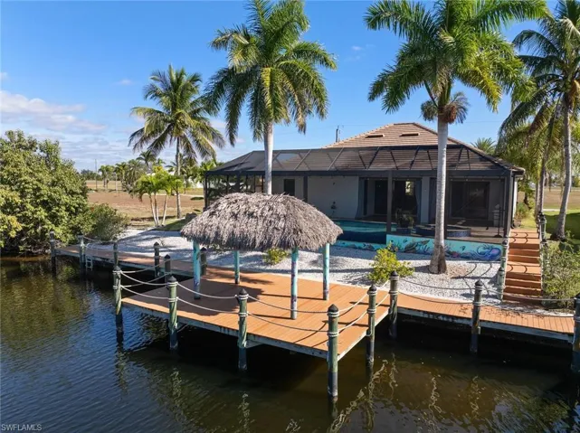 Dock with a lanai, a sunroom, a water view, and a pool