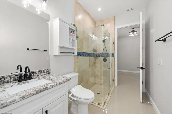 Bathroom with a stall shower, vanity, and light tile patterned flooring