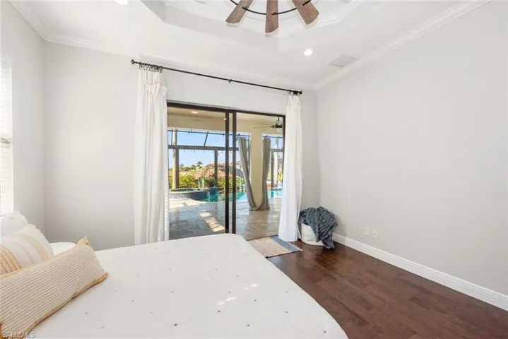 Bedroom featuring recessed lighting, access to outside, dark wood-type flooring, a sunroom, and ornamental molding