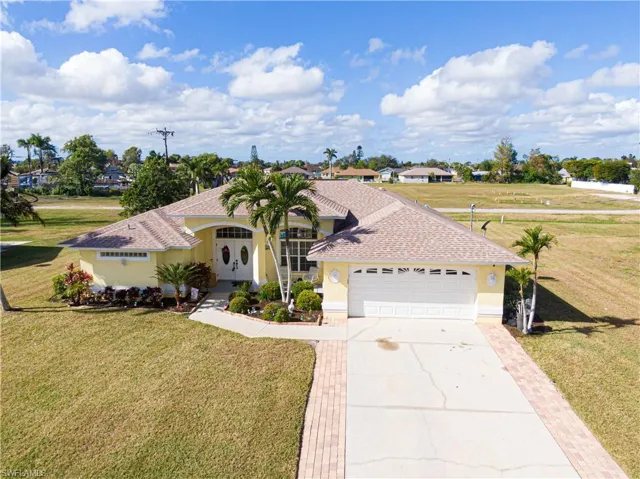 View of front of property featuring a garage and a front lawn
