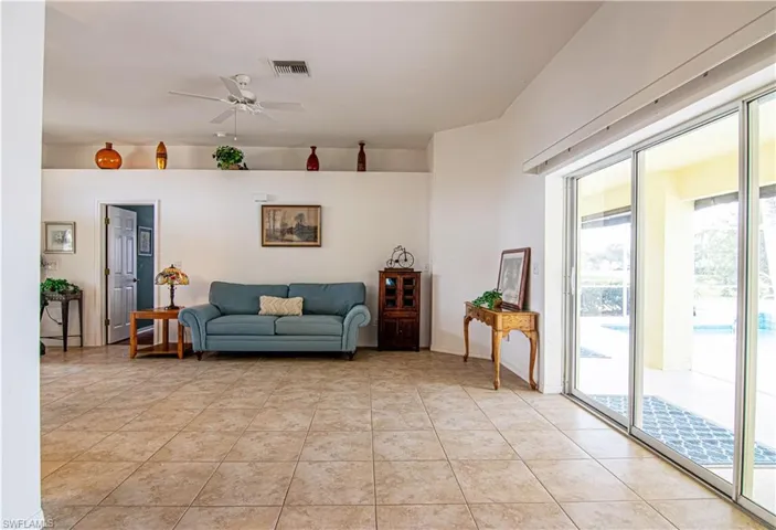 Living room featuring light tile patterned floors and ceiling fan