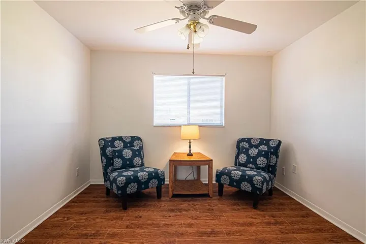 Sitting room featuring dark hardwood / wood-style flooring and ceiling fan
