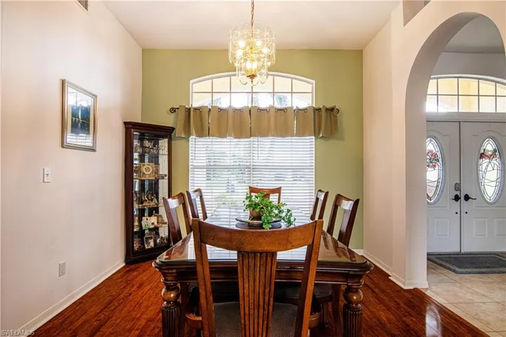 Dining space featuring dark hardwood / wood-style flooring and an inviting chandelier