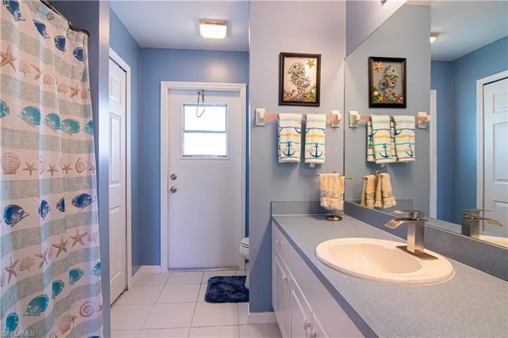 Bathroom with tile patterned flooring, vanity, toilet, and a shower with shower curtain