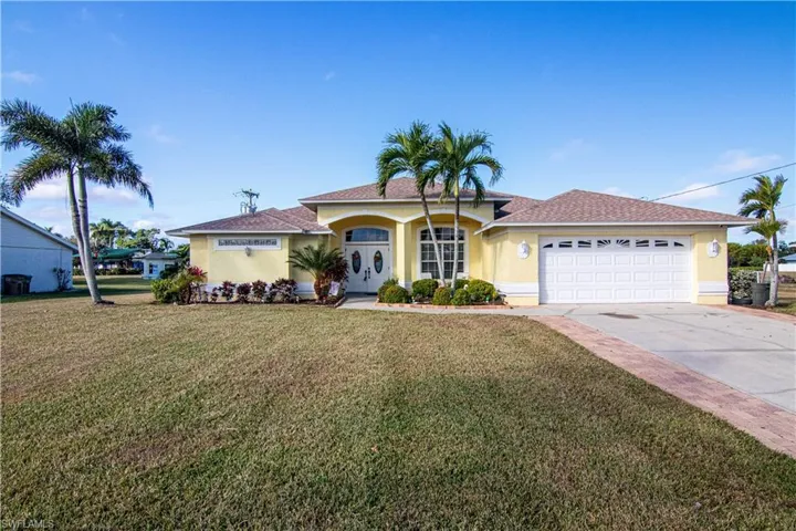 View of front of home featuring a front lawn and a garage