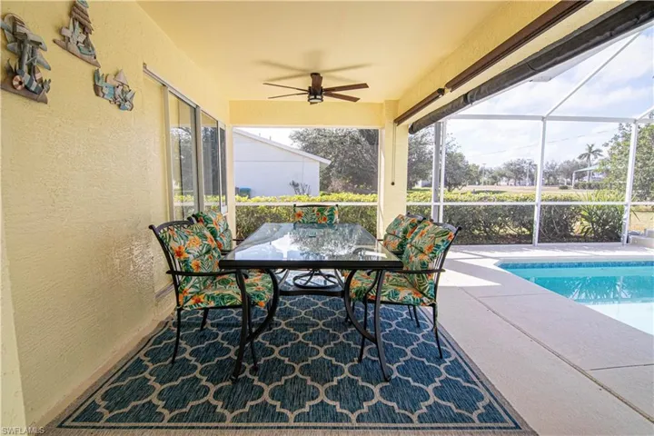 Sunroom / solarium with ceiling fan, a swimming pool, and a healthy amount of sunlight