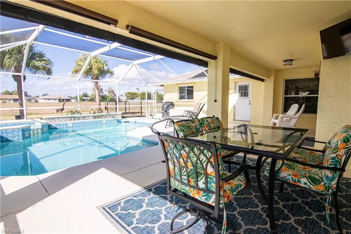 View of pool with an in ground hot tub, a lanai, and a patio area