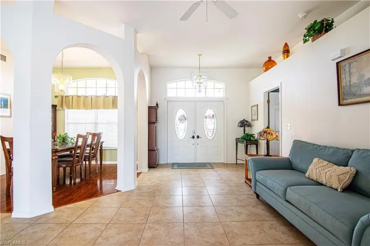 Entrance foyer with ceiling fan with notable chandelier and light hardwood / wood-style flooring