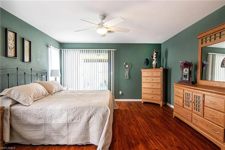 Bedroom with ceiling fan and dark hardwood / wood-style floors