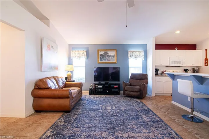 Living room featuring ceiling fan and light tile patterned floors