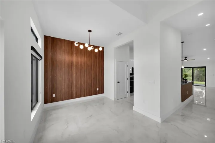 Spare room featuring wooden walls, marble finish floor, an accent wall, recessed lighting, and baseboards