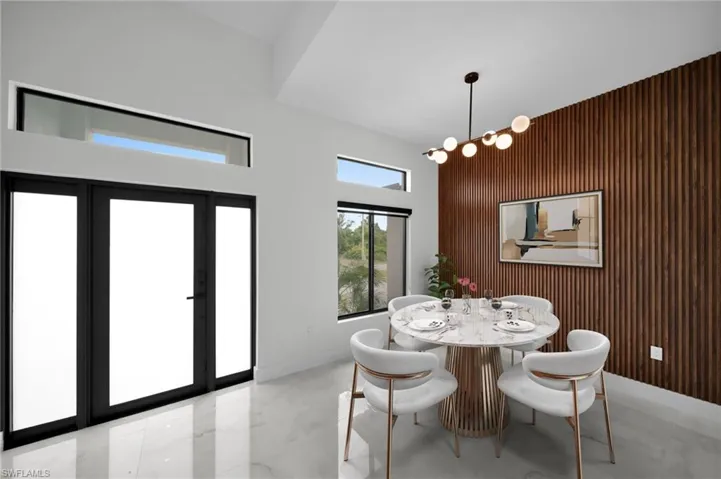 Dining room featuring a high ceiling, a chandelier, and marble finish floor
