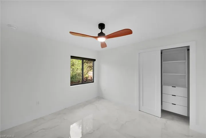 Unfurnished bedroom with baseboards and marble finish floor