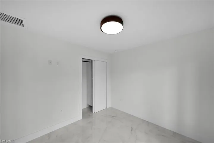 Unfurnished room featuring baseboards, marble finish floor, and visible vents