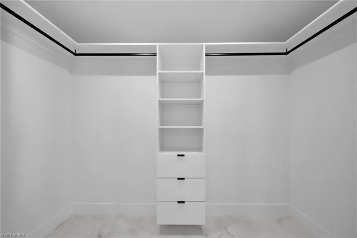 Walk in closet featuring marble finish floor