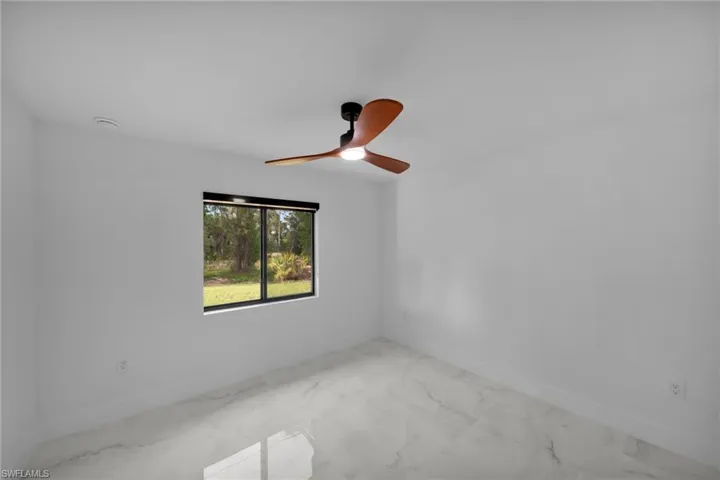 Spare room with baseboards, marble finish floor, and ceiling fan
