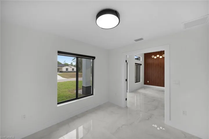Spare room with baseboards, marble finish floor, and visible vents
