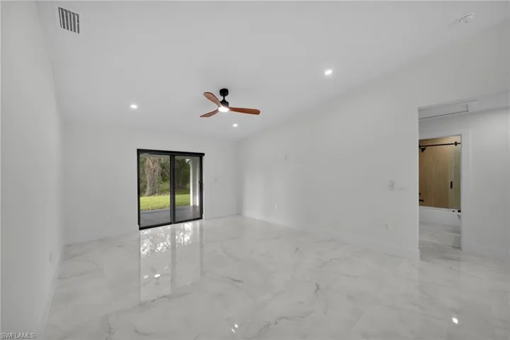 Empty room with visible vents, marble finish floor, baseboards, ceiling fan, and recessed lighting