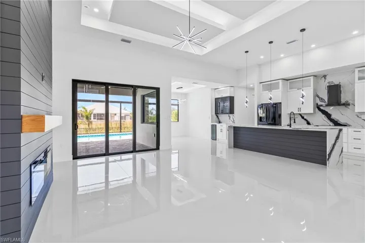 Living room with a chandelier, a fireplace, recessed lighting, beam ceiling, and light tile patterned floors