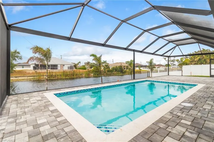 Outdoor pool featuring a patio, a residential view, and a water view