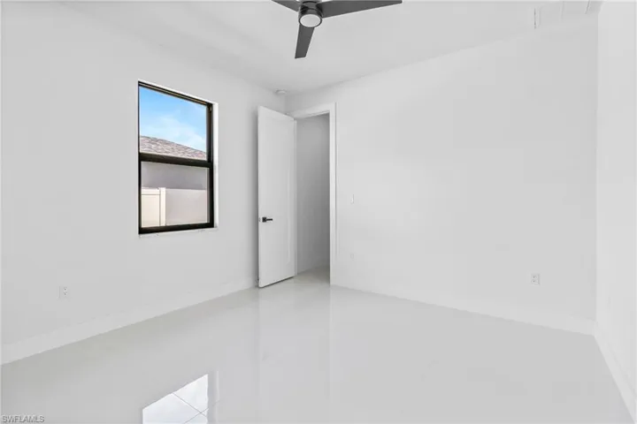 Tiled spare room with baseboards and a ceiling fan