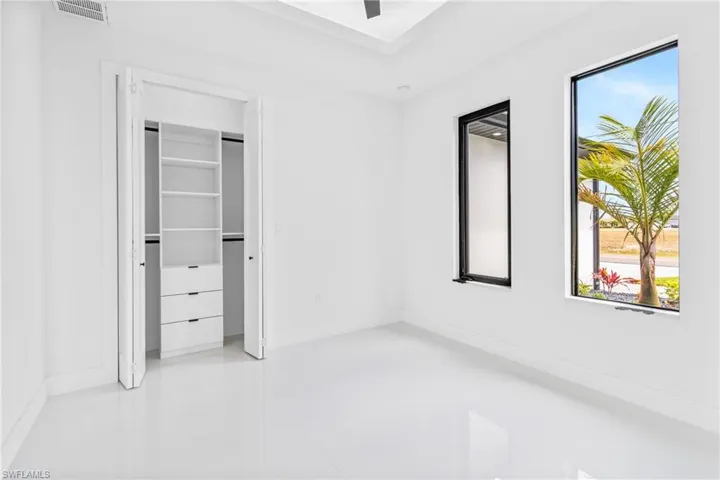 Unfurnished bedroom with light tile patterned floors and ceiling fan