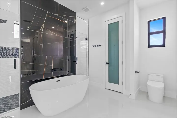 Bathroom featuring a freestanding bath, a stall shower, and recessed lighting