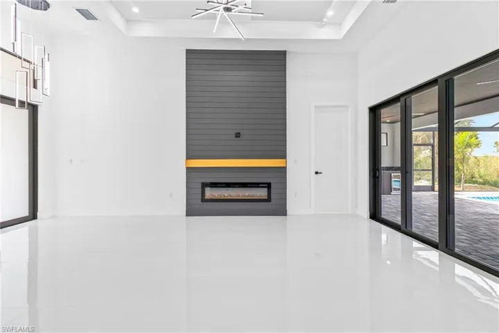 Corridor with tile patterned flooring, a tray ceiling, and recessed lighting